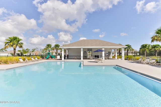 pool with playground community, a patio, and fence