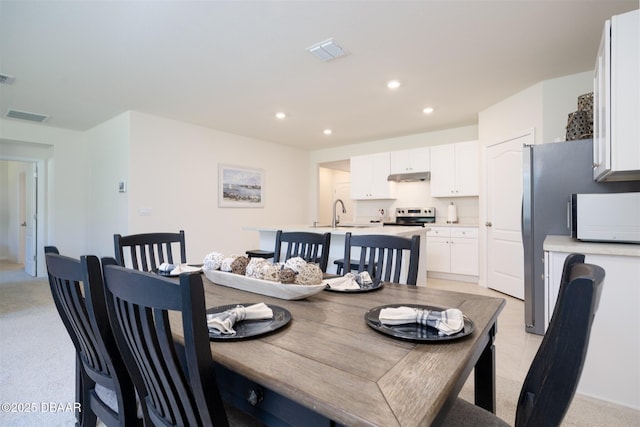 dining room with light colored carpet, recessed lighting, and visible vents