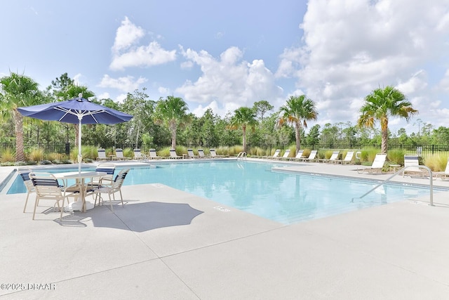 community pool featuring fence and a patio