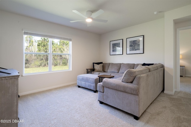 living room featuring baseboards, a ceiling fan, and light colored carpet