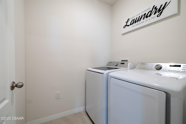 laundry room with laundry area, light tile patterned floors, baseboards, and washer and dryer