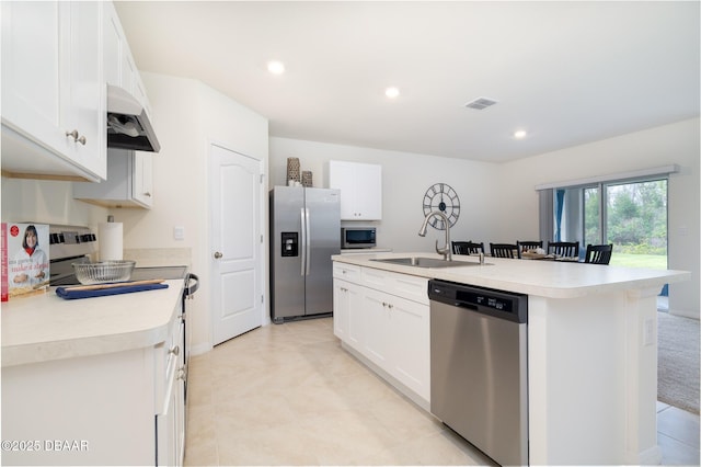 kitchen featuring appliances with stainless steel finishes, light countertops, a sink, and under cabinet range hood