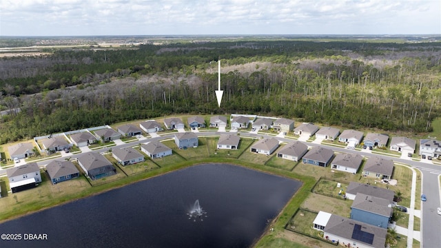 drone / aerial view featuring a water view, a residential view, and a wooded view