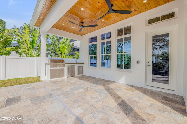 view of patio / terrace with an outdoor kitchen, a ceiling fan, area for grilling, and fence