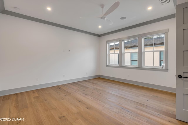 spare room with baseboards, light wood-type flooring, visible vents, and ceiling fan