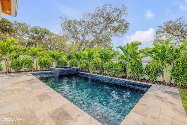 view of swimming pool with a fenced backyard, a pool with connected hot tub, and a patio area