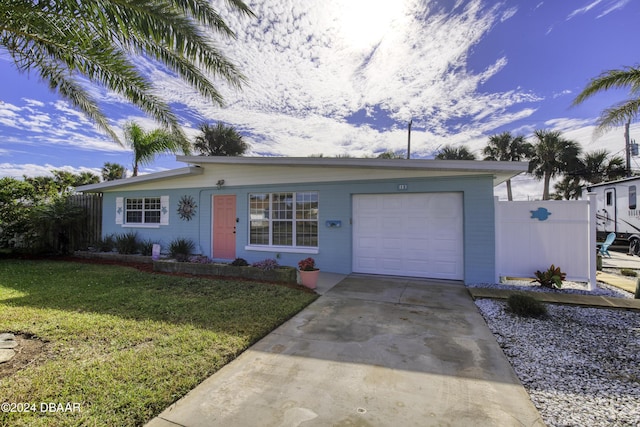 ranch-style home featuring a garage and a front lawn