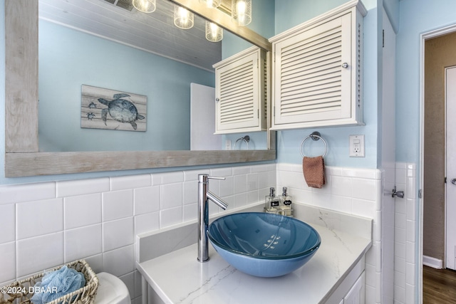 bathroom with sink and tile walls