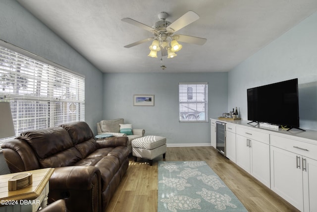 living room with ceiling fan, a wealth of natural light, and light hardwood / wood-style flooring