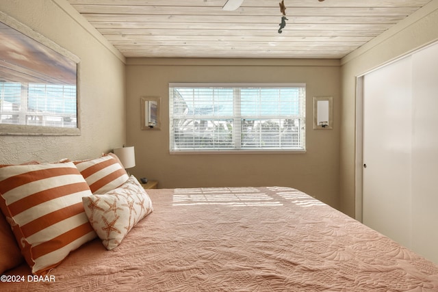 bedroom with wood ceiling and track lighting