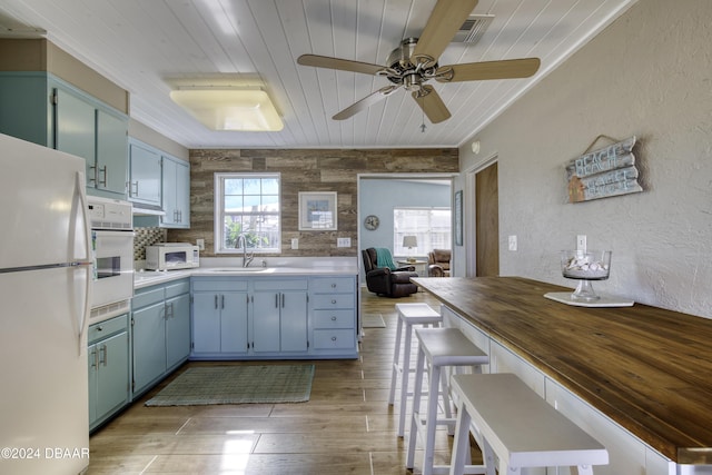 kitchen featuring ceiling fan, a wealth of natural light, sink, and white appliances