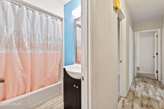 bathroom with vanity, a textured ceiling, and shower / bathtub combination with curtain