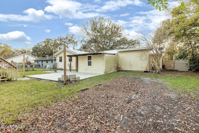 rear view of property with a lawn and a patio area