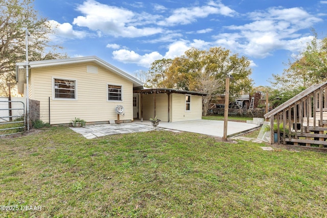 back of house with a patio area and a lawn