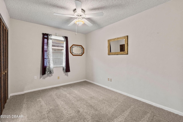 unfurnished room featuring ceiling fan, carpet, and a textured ceiling