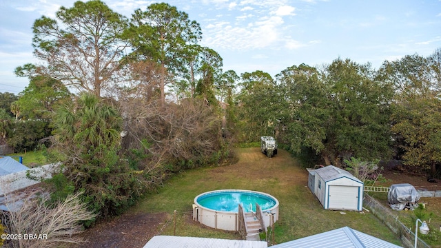 view of swimming pool with a yard and a storage unit