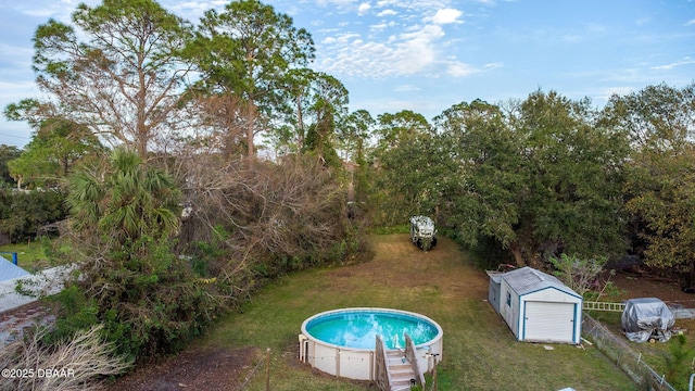 view of pool with a yard and a storage shed