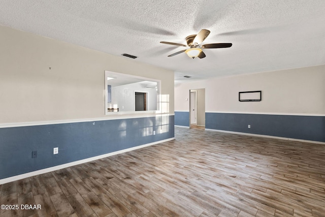 unfurnished room with hardwood / wood-style flooring, a textured ceiling, and ceiling fan