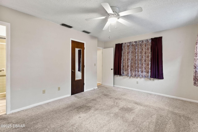 carpeted empty room with ceiling fan and a textured ceiling