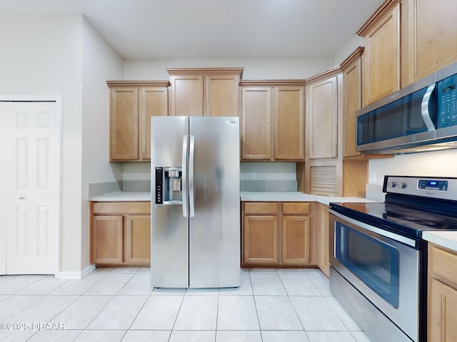 kitchen with light tile patterned flooring and appliances with stainless steel finishes