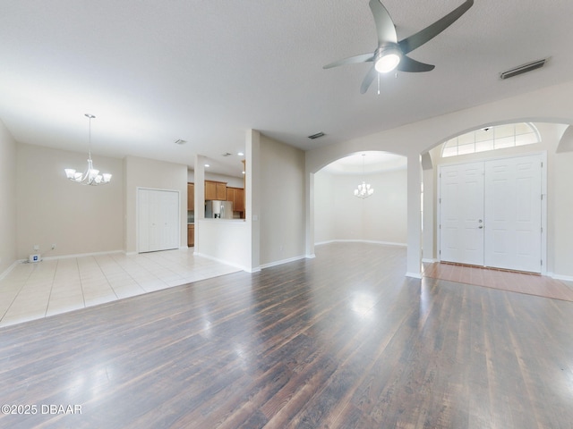 spare room featuring ceiling fan with notable chandelier, hardwood / wood-style floors, and a textured ceiling