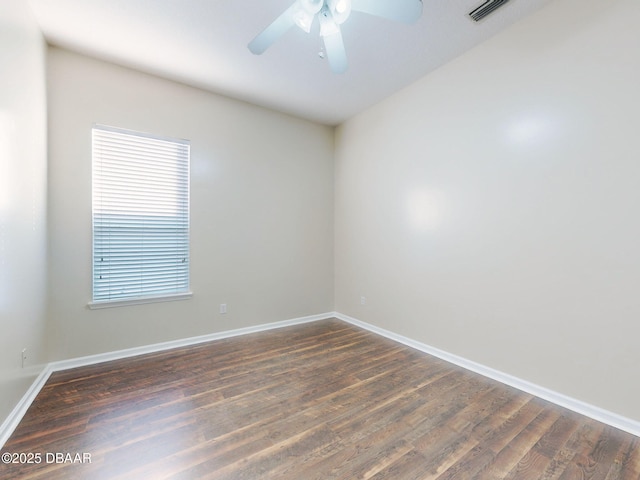 empty room with ceiling fan and dark hardwood / wood-style flooring