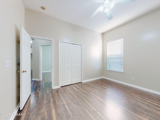 unfurnished bedroom featuring ceiling fan, dark hardwood / wood-style flooring, and a closet