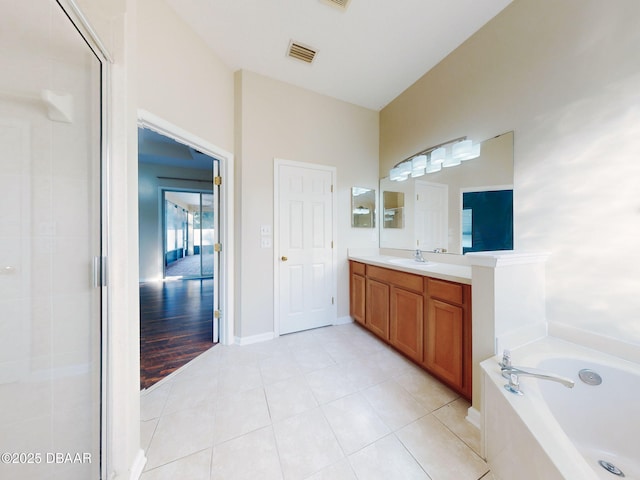 bathroom with vanity, a washtub, and tile patterned floors