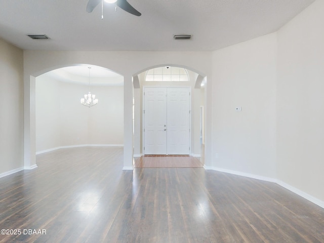 unfurnished dining area featuring hardwood / wood-style floors, ceiling fan with notable chandelier, and a raised ceiling