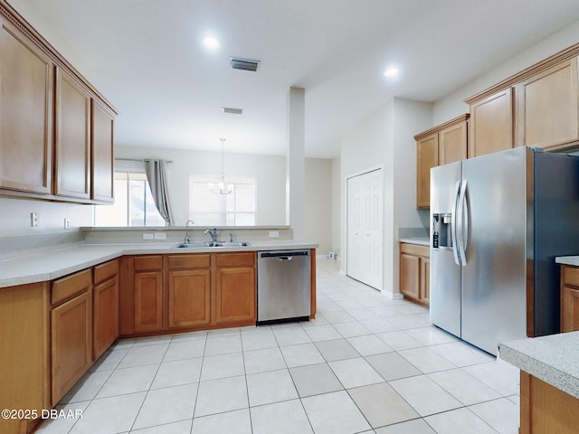 kitchen featuring sink, light tile patterned floors, a notable chandelier, pendant lighting, and stainless steel appliances