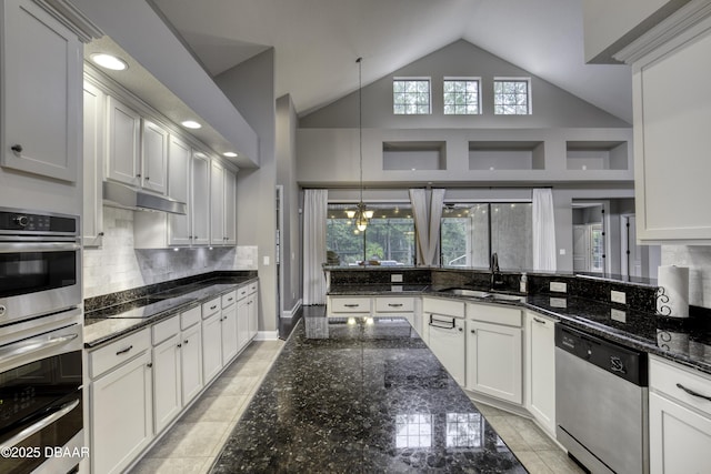 2809 Oakgrove Ave, Saint Augustine, FL 32092 - kitchen with stainless steel appliances, dark stone counters, backsplash, white cabinetry, and high vaulted ceiling