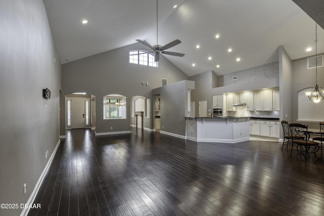 2809 Oakgrove Ave, Saint Augustine, FL 32092 - unfurnished living room featuring high vaulted ceiling, arched walkways, a ceiling fan, healthy amount of natural light, and dark wood-style flooring