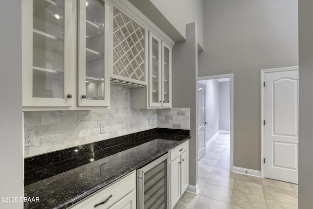 2809 Oakgrove Ave, Saint Augustine, FL 32092 - kitchen featuring beverage cooler, dark stone countertops, a high ceiling, light tile patterned floors, and decorative backsplash