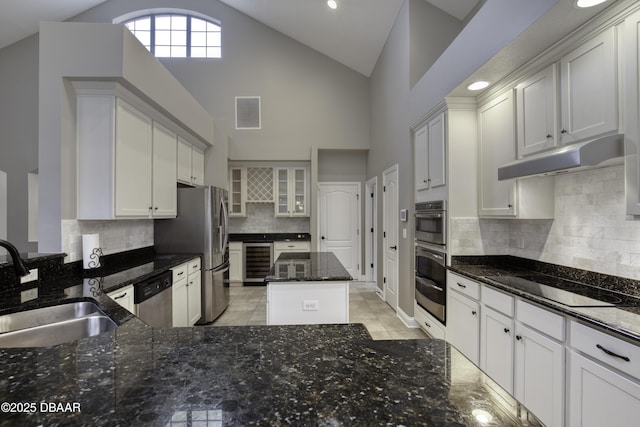 2809 Oakgrove Ave, Saint Augustine, FL 32092 - kitchen featuring appliances with stainless steel finishes, beverage cooler, dark stone countertops, decorative backsplash, and high vaulted ceiling