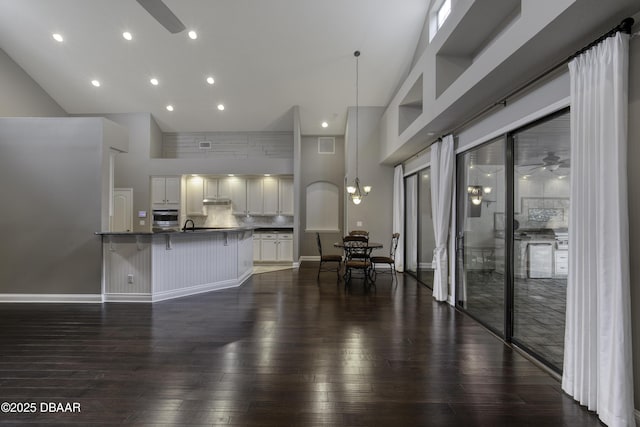 2809 Oakgrove Ave, Saint Augustine, FL 32092 - kitchen featuring a ceiling fan, dark countertops, a kitchen bar, stainless steel oven, and white cabinetry