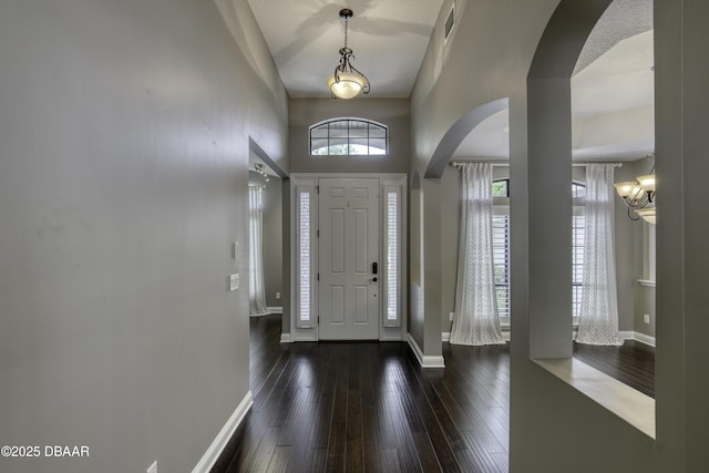 2809 Oakgrove Ave, Saint Augustine, FL 32092 - entryway featuring arched walkways, dark wood-style floors, a chandelier, and a towering ceiling