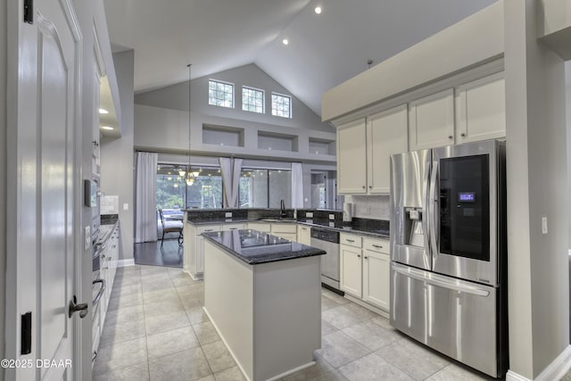 2809 Oakgrove Ave, Saint Augustine, FL 32092 - kitchen featuring stainless steel appliances, a peninsula, a kitchen island, dark stone countertops, and light tile patterned flooring