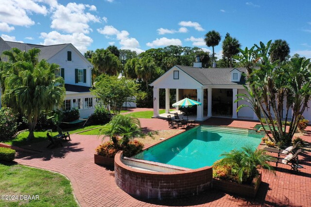 view of swimming pool with a hot tub and a patio area