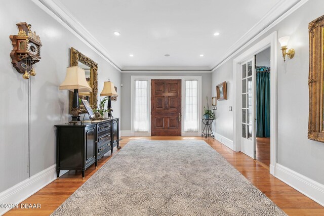 entrance foyer featuring ornamental molding and light wood-type flooring