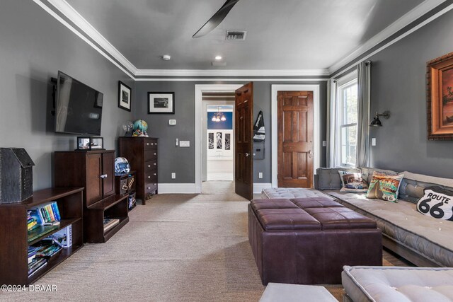 living room with ceiling fan, light carpet, and ornamental molding