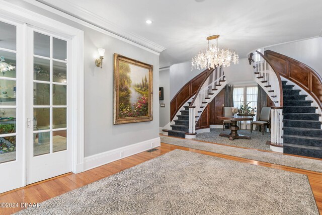 interior space with ornamental molding, hardwood / wood-style floors, and a notable chandelier