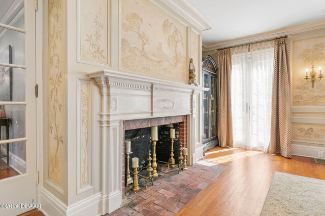 living room with a fireplace, hardwood / wood-style flooring, crown molding, and plenty of natural light