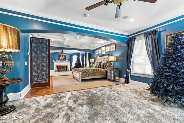 bedroom with beamed ceiling, ceiling fan, hardwood / wood-style floors, crown molding, and coffered ceiling