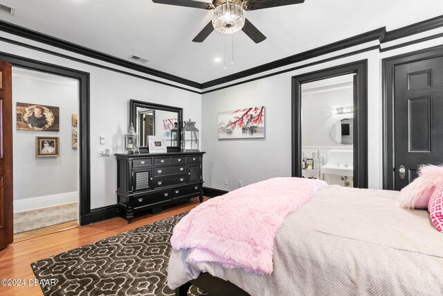 bedroom featuring ensuite bathroom, ornamental molding, wood-type flooring, and ceiling fan