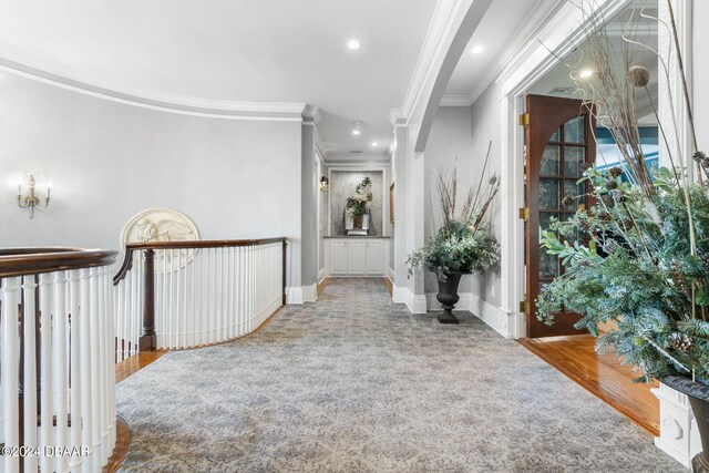 hallway featuring light wood-type flooring and ornamental molding