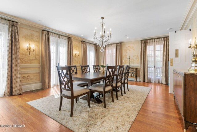 dining space featuring light wood-type flooring, a chandelier, and crown molding