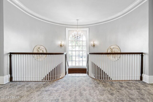 interior space with carpet, a notable chandelier, and crown molding