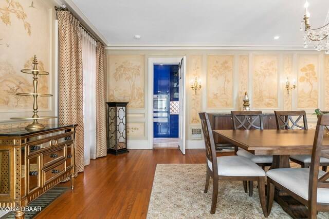 dining room featuring ornamental molding, dark wood-type flooring, and an inviting chandelier