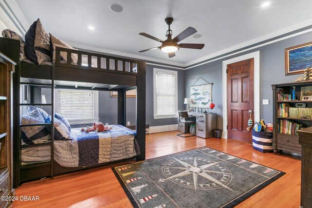 bedroom with ornamental molding, wood-type flooring, and ceiling fan