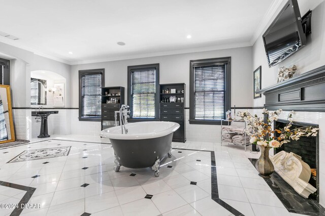 bathroom with tile patterned floors, a bathing tub, tile walls, and ornamental molding